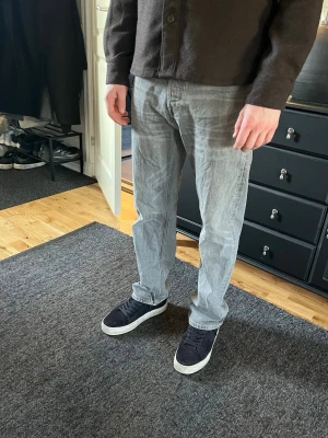 Grå jeans från Weekday - Snygga grå jeans från Weekday. Storlek 28, längd 30 (han i bild är 180cm). Mycket bra skick, inga skador. Köpt för något år sedan men kommer inte till användning längre. Skriv vid frågor!!