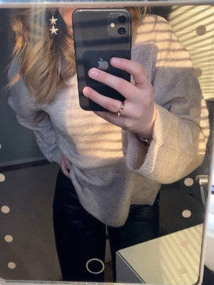 Beige croppad stickad tröja - Mysig beige stickad tröja med croppad passform och långa ärmar. Tröjan har rund halsringning och ribbstickade muddar vid ärmslut och nederkant. Perfekt för lager-på-lager och enkel att matcha med jeans eller kjol.