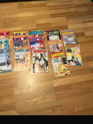 Larson! serietidningar samling - En samling färgglada Larson! serietidningar med humoristiska omslag och klassiska tecknade serier. Perfekt för dig som gillar skruvad humor och vill ha en rolig läsupplevelse. Omslagen har olika motiv och färger, och tidningarna är i pocketformat.