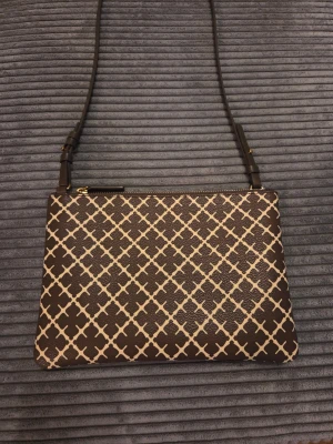 Malene Birger väska  - Väskan har dragkedja upptill och är tillverkad i ett tåligt konstlädermaterial. Perfekt för dig som gillar stilrena accessoarer med lite edge.