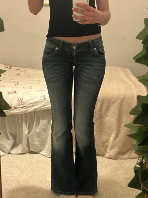 Mörkblå utsvängda jeans med låg midja - Mörkblå utsvängda jeans med låg midja. Storlek xs och längd short, passar de 166 eller under.I Modellen blaze från Lager 157. Köpta för 400kr och endast testade. Pris kan diskuteras!!