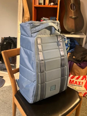 Blå ryggsäck från Db - Snygg blå ryggsäck från Douchebag i färgen fog blue eller ljusblå. Jag har inga fler bilder just nu men ska ta fler. Allt fungerar som den ska och ser bra ut.