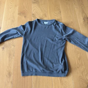 Mörkgrå långärmad tröja Woolrich - Helt oanvänd mörkgrå långärmad tröja från Woolrich. Tröjan har rund halsringning och är tillverkad i ett mjukt material som känns skönt mot huden. Tröjan passar circka 165, storlek är för 14-åringar.