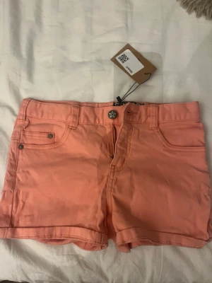 Korallrosa shorts från Molo Jeans - Snygga korallrosa shorts från Molo Jeans Shorts, storlek XS/XXS. Kommer ny ifrån sellpy! 