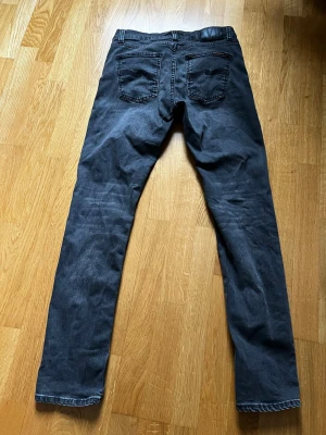 Nudie Jeans Lean Dean  - Snygga grå jeans med rak passform och klassisk femficksdesign. Jeansen har diskreta slitningar och kontrastsömmar. Materialet är denim i bomull.