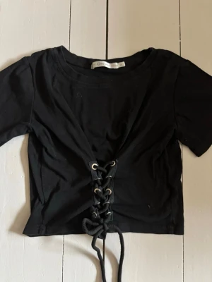 Topp med snörning - Trendig topp med snörning på framsidan, knappt använd! Skicka prisförslag 🥰