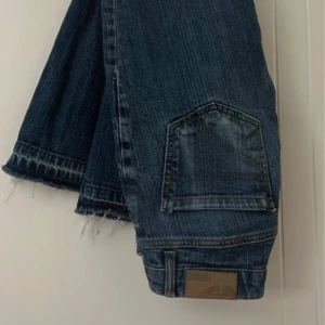 Vintage Low Jeans  - Säljer ett par blå vintage jeans i denim från ARIZONA. Byxorna har en bootcut passform med låg/medelhög midja för en cool och trendig look. De är uppsprättade nertill (se bild 3) sant har en visst nött backficka (se bild 2). Det saknar storlek på jeansen men jag skulle säga att de passar som en S. Jag är 157 för referens (se sista bild)💝