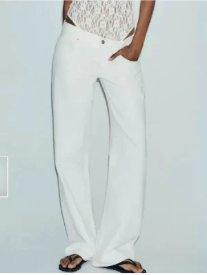 Zara jeans - Säljer ett par vita jeans med medel hög midja och breda, raka ben. Storlek 34 och i nästan ny skick då de är använda en gång!