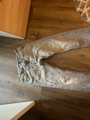 Ljusgrå raka jeans från Weekday - Säljer ett par ljusgrå jeans från Weekday med klassisk femficksmodell och raka ben. Jeansen har normal midja och är tillverkade i denim med en snygg tvättad look. Perfekta för en avslappnad och trendig stil.