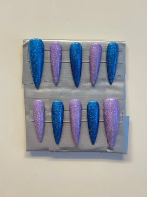 Press On Nails & Fingerlösa Vantar || Size M - Söta långa stilletto holografiska naglar i lila och mörkblå färg. Kommer tillsammans med ett par handgjorta fingerlösa vantar💜Det du får med dig : * Fil och manikyr pinne * nagellim klistermärken * 2 lappar av rengöring för naglar.