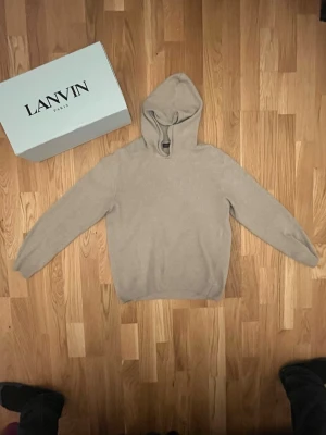 Beige hoodie Oscar Jacobson - Mjuk och stilren beige hoodie från Oscar Jacobson . Tröjan har en klassisk huva och långa ärmar, perfekt för en avslappnad och trendig look. Tillverkad i ett mjukt material som känns skönt mot huden. Enkel design utan tryck eller mönster. Priset går att diskuteras 