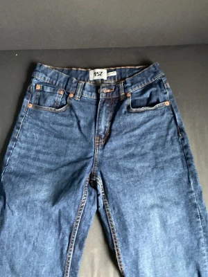 Blå raka jeans från 157 - Snygga blå jeans från 157 med klassisk femficksmodell och raka ben. Jeansen har en djup indigo färg, kopparfärgade nitar och kontrastsömmar. Tillverkade i slitstark denim som passar perfekt till en avslappnad stil.