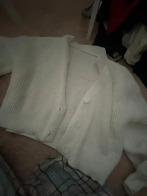 Vit ribbstickad kofta med knappar - Säljer en vit ribbstickad kofta med v-ringning , aldrig andvönd bra skick.