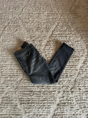 Dondup George jeans - Hej just nu säljer vi dessa väldigt fina Dondup George jeans med slitningar i grå färg. Storlek på dessa är 31. Skicket på dessa är 9/10 utan defekter. Midja 38cm. Lår 23cm. Ytterlängd 87cm. Innerlängd 60cm. För fler frågor eller fundering är det bara att höra av sig