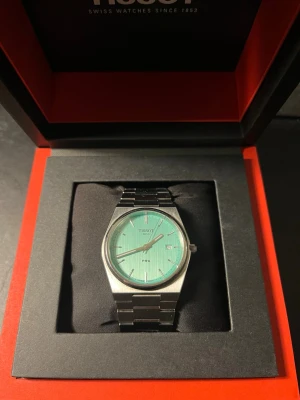 Tissot PRX Quartz Lime Grön - Tissot PRX klocka med Lime Grön urtavla och datumvisning. Boetten och länken är i borstat stål för en clean och modern look. Kommer i originalbox med manual och garantikort. Perfekt accessoar för dig som gillar stilrena detaljer. Finns ett antal ”hårstrån” (repor) på armbandet men själva glaset är i perfekt skick.
