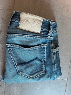 Blå jeans från Jacob Cohen - Sjukt snygga blå jeans från Jacob Cohen.🔥Använda men i ett gott skick! Midja 38 cm och längd 96 cm.☺️Jeansen är i slimfit/regular. Ända defekten är ett lagat hål mellan benen! Tvivla inte på att höra av er vid eventuella frågor 👍