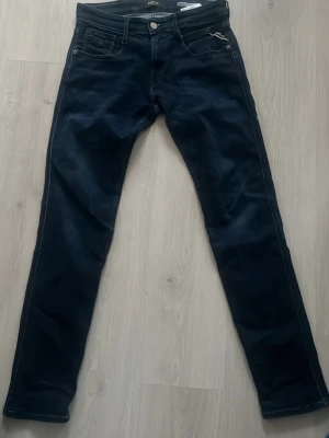 Mörkblå slim jeans från Replay - Snygga mörkblå slim fit jeans från Replay med klassisk femficksdesign och diskret logga vid fickan. Jeansen har raka ben och är tillverkade i ett mjukt denimtyg som ger en skön passform. Perfekta för dig som gillar stilrena jeans för bra pris,  nypris, 1100kr 