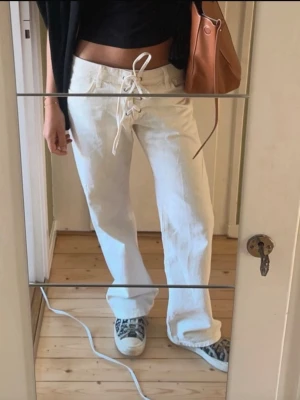 Vita Zara jeans  - Säljer dessa mod waist Zara jeans med knytning framtill perfekta till sommaren🩷Jensen är beige/Vita Jag Säljer då de ej kommer till andvändning längre. Jeansen kan vara lite skadad läst ner vid foten men inget som märks vid första anblick🩷