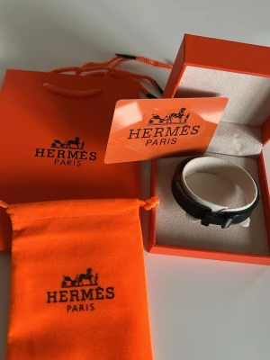 Svart armband i härdat stål  - Snyggt svart armband med metallspänne format som ett H. Kommer i originalförpackning med tillhörande påse och certifikat. Perfekt accessoar för dig som gillar exklusiva detaljer och stilren design.