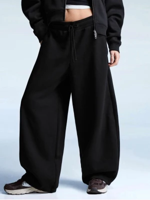 Svarta mjukisbyxor Bershka - Säljer ett par svarta mjukisbyxor från Bershka med riktigt bred passform och dragsko i midjan. Byxorna har sidofickor och är gjorda i mjukt sweatshirtmaterial, perfekta för en chill och avslappnad stil. Passar dig som gillar oversized och streetwear. iets frans liknande💗