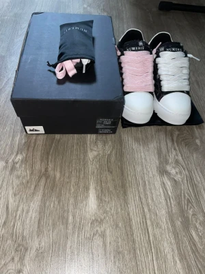 Numeris pink denim - Ett par stilrena svart-rosa Numeris-skor i nyskick säljes. Skorna är helt oanvända och finns i storlek 43. Vid intresse kan fler bilder och video skickas för en närmare titt. Seriösa bud välkomnas. Observera att originalkartongen är något skadad, men fungerar fortfarande för förvaring av skorna.
