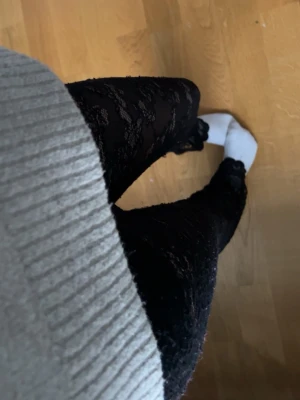 Svarta spetsstrumpbyxor - Säljer ett par svarta strumpbyxor med snyggt spetsmönster. De är tunna och har ett genomskinligt, blommigt mönster som ger en trendig look. Perfekta att styla med kjol eller klänning för en cool outfit.