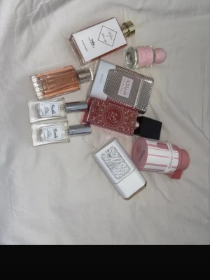 Mix av parfymer i olika färger - Säljer ett set med flera parfymer från olika märken. Flakongerna är i glas och plast, med färger som rosa, vitt, silver och guld. Några har metalliska detaljer och unika former, vissa med dekorativa lock. Perfekt för dig som vill testa olika dofter och stilar. 