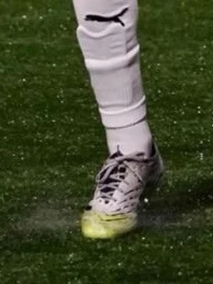 Adidas grå fotbollsskor med gula detaljer - Säljer ett par snygga Adidas fotbollsskor i grått med svarta och gula detaljer. Skorna har snörning, låg profil och är tillverkade i syntetmaterial med textur för bättre bollkontroll. Perfekta för dig som vill sticka ut på planen.