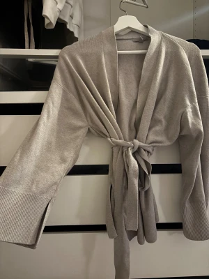 Ljusgrå stickad morgonrock - Kofta från h&m i en grå/beige färg.Storlek S