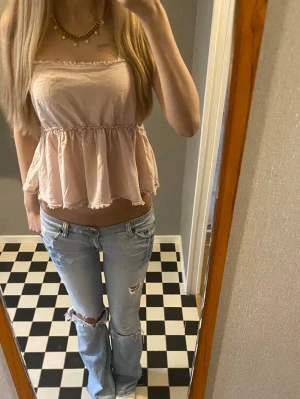Ljusros topp med volang - Säljer denna ljusrosa toppen från saint tropez i storlek m men skulle mer säga att den passar som än s