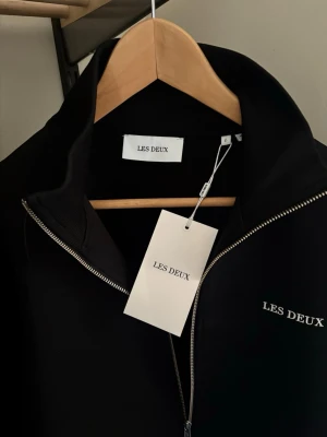 Les Deux BALLIER TRACK JACKET - Träningsjacka - black - Ny! Oanvänd med lapp kvar. Snygg svart tröja från Les Deux med hel dragkedja framtill och diskret logga på bröstet. 