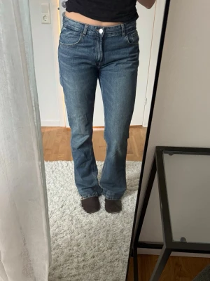 Blå bootcut jeans från Zara - Säljer ett par snygga bootcutjeans från Zara. Jeansen är mörkblåa och långa i benen (jag är 175cm som referens). 