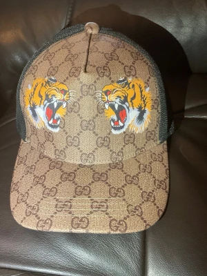 Gucci keps - Säljer min Gucci Keps då jag inte använder den längre och har köpt en ny. Jag har endast använt den några gånger den är helt fläckfri och har inga defekter. Skriv för mer frågor.