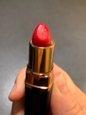 Rött läppstift från Inglot  - Snyggt rött läppstift från Inglot med klassisk guldig och svart hylsa. Läppstiftet har en krämig formula och ger en intensiv färg med en elegant finish. Perfekt för dig som vill ha en djärv look och gillar lyxig design. I samarbete med Jennifher Lopez