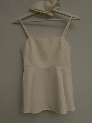 Sommartopp - Fin sommartopp som sitter spänt vid midjan men lösare längre ner. 