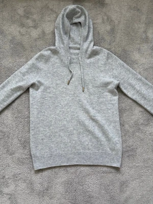 Merino ull hoodie  - Tjena, Säljer denna Ljusgråa Merino ull hoodie som är extremt fin och mysig. Den är iprincip helt oanvänd och skicket är 9/10. Den är i storlek S och jag skulle säga att den passar alla från 165-180. Mitt pris ligger på 400kr och tveka ej på att höra av er för fler bilder eller frågor.