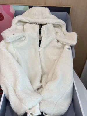 Vit teddyjacka med huva från Alo - Supermjuk och fluffig teddyjacka från Alo i krämvit färg. Jackan har dragkedja framtill, stor huva och ribbade muddar vid ärmsluten. Perfekt för kalla dagar när du vill vara både varm och stylish. Materialet är teddy/fleece som ger en mysig känsla.