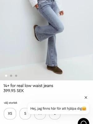 Blå low waist bootcut jeans - Säljer ett par ljusblå low waist jeans från 14+ for real med bootcut-modell. Jeansen har klassiska fem fickor, dragkedja och knapp framtill samt en snygg tvättad look. Perfekta för dig som gillar retrovibbar och vill ha en avslappnad men trendig stil.