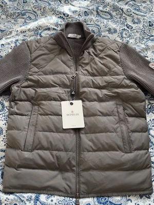 Moncler Cardigen - Säljer denna Moncler cardigan. Den är i nyskick men lite fabriksfel. Det stickade är väldigt fint. Storleken är L men sitter som en S/XS