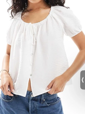 Vit blus med knappar och kort ärm - Söt vit blus med korta puffärmar och knappar framtill.
