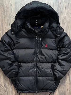 Svart pufferjacka från Polo Ralph Lauren - Snygg svart pufferjacka från Polo Ralph Lauren. Storlek S i mycket bra skick men inga defekter alls.