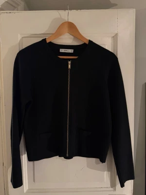 Kofta  - Lättstickad kofta med guld dragkedja framtill