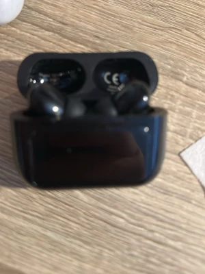 Svarta trådlösa in-ear hörlurar - Snygga svarta trådlösa in-ear hörlurar med laddningsetui. Hörlurarna har en stilren och kompakt design med blanka ytor och mjuka silikontoppar för bekväm passform. Perfekta för musik, poddar och samtal på språng.