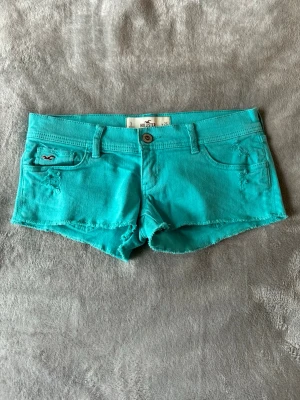 Turkosa lågmidjade korta jeansshorts Hollister - Supersnygga turkosa korta lågmidjade jeansshorts från Hollister. Storlek 26, skulle säga S. Midjemått finns i bilderna! Bra skick❤️