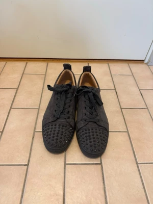 Christian Louboutin grå sneaker med nitar - Tja, jag säljer ett par gråa sneakers i mocka från Christian Louboutin med nitar på tån! Storlek 43, bra skick! (Kvitto finns)
