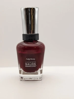 Sally Hansen red zin rött nagellack 85% kvar - Snyggt mörkrött nagellack från Sally Hansen Complete Salon Manicure i nyansen 610 Red Zin. Kommer i en stilren glasflaska med silverfärgat lock. Perfekt för dig som vill ha en djup, elegant färg på naglarna.