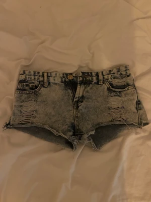 Blå lågmidjade jeansshorts - Snygga blå jeansshorts med väldigt låg midja och slitna detaljer. Storlek XS och är tyvärr lite för små för mig💕💕 