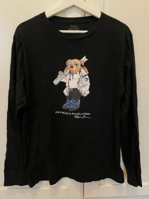 Ralph Lauren långärmad t-shirt - Svart långärmad t-shirt från Ralph Lauren med ikoniskt Polo Bear-tryck framtill. 