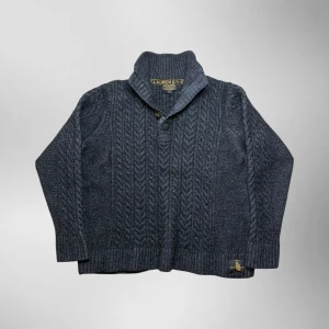 Vintage Ralph Lauren premium 1/4 button up grovstickad tröja - herr strl XL - Säljer en vintage Ralph Lauren mycket sällsynt premium 1/4 button up grovstickad tröja i mörkgrå färg i storlek XL med kabelstickat mönster samt Ralph Lauren New York brodering nedtill på vänster sida.  👕 Märke: Ralph Lauren 📏 Storlek: XL 🎨 Färg: Mörkgrå 🧵 Material: 49% ull, 27% akryl, 24% alpacka 📐 Mått: 66 cm lång, 56 cm bred 📌 Skick: Mycket bra skick (se bilder)  💬 Hör av dig vid frågor 💰 Pris kan diskuteras vid snabb affär 📦 Skickas inom 24 timmar