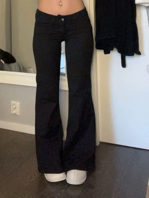 Svarta bootcut jeans  - Säljer ett par svarta bootcut jeans med super låg midja ifrån Weekday . Storlek 28/30 sitter som en storlek xs 